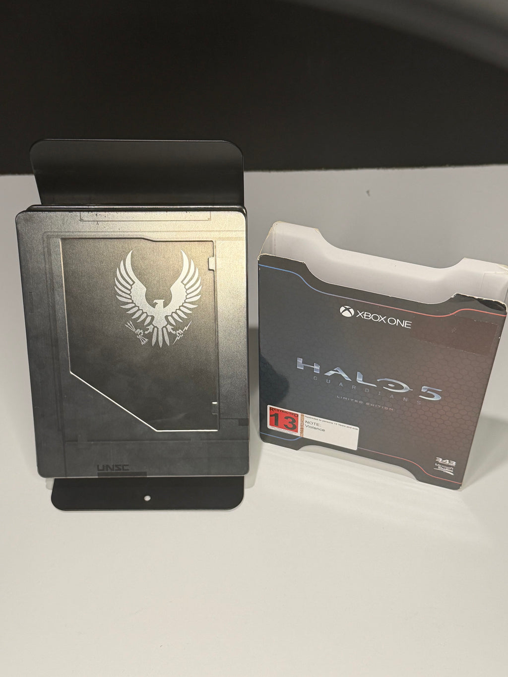 Halo 5 Guardians Limited Edition SteelBook front showing embossed UNSC phoenix crest alongside original Limited Edition inner box back panel