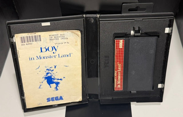 Wonder Boy in Monster Land Sega Master System open case showing heavily worn manual with creased dog-eared corners and yellowing and SMS cartridge