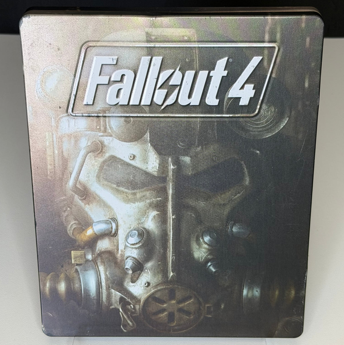 Fallout 4 SteelBook Edition PS4 front showing T-60 Power Armor torso with Fallout 4 logo on full-art printed metal case