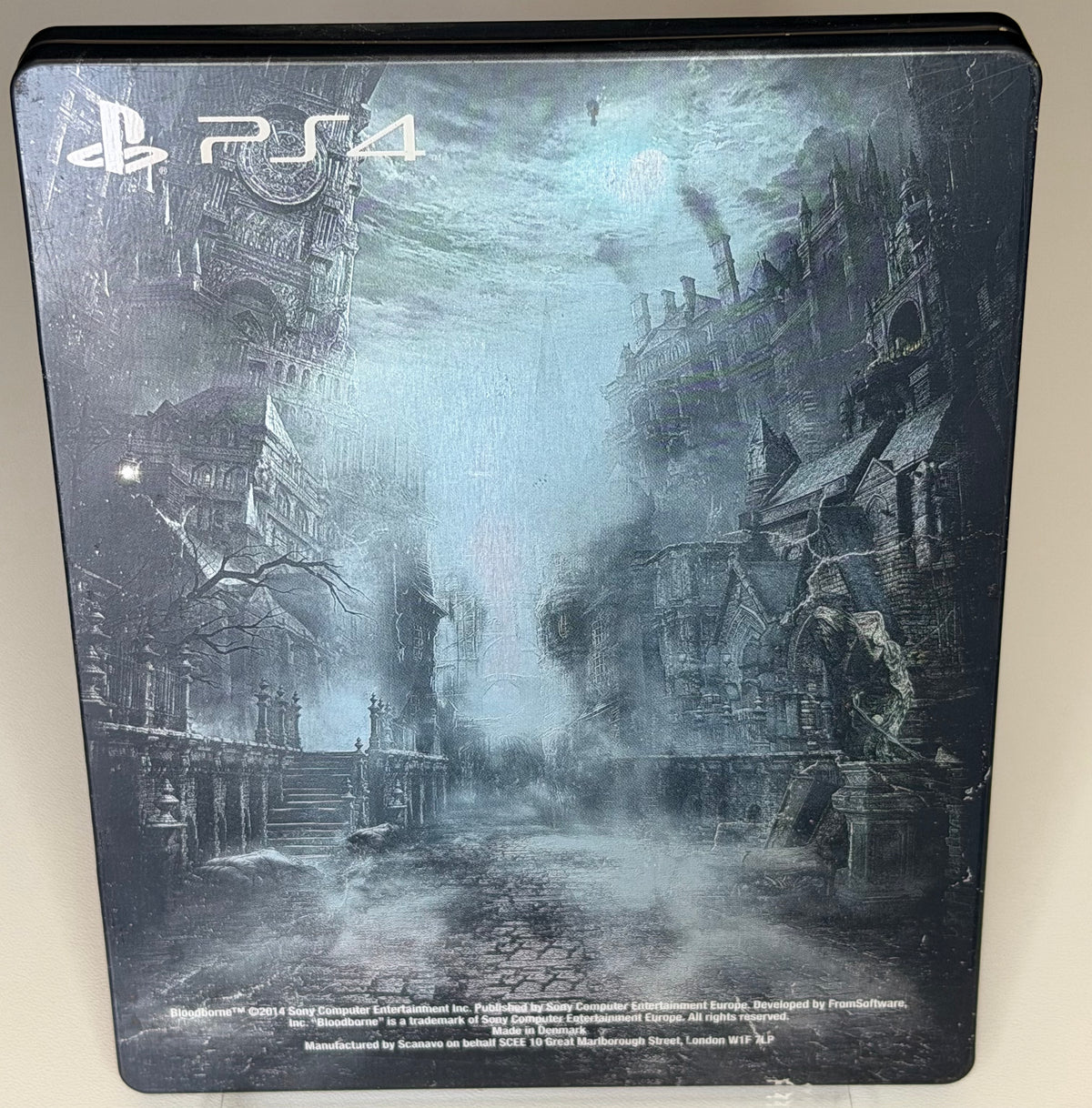 Bloodborne SteelBook Edition PS4 back showing atmospheric Yharnam cityscape panorama on full-art metal case made in Denmark by Scanavo