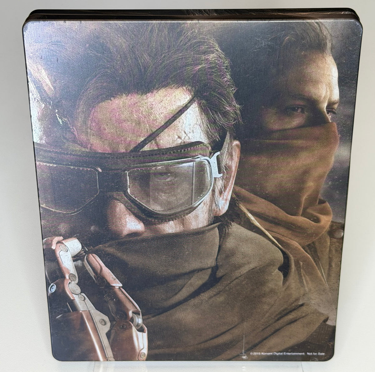 Metal Gear Solid V Phantom Pain Day One SteelBook PS4 back showing Venom Snake in goggles with bionic arm and Quiet masked on full-art metal case with Not for Sale text