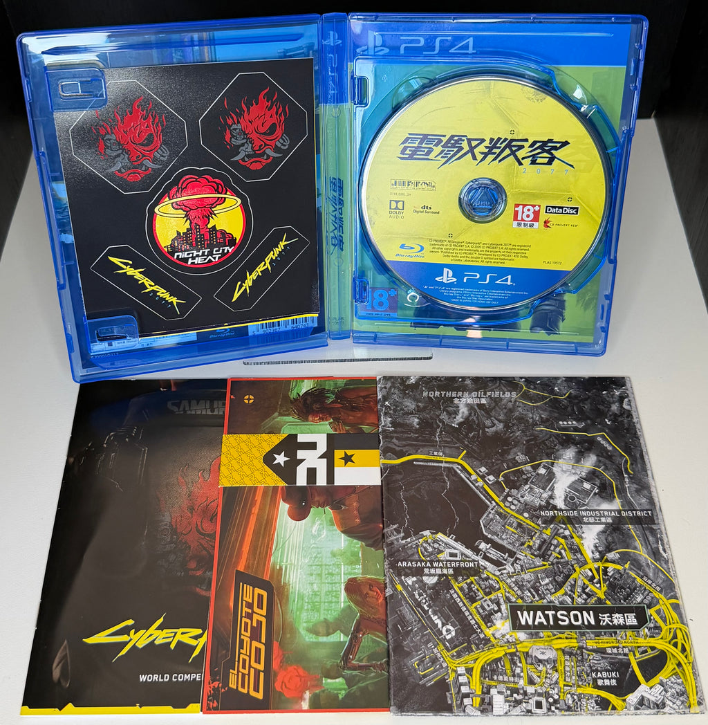 Cyberpunk 2077 PS4 Asian edition front cover showing V holding gun with yellow background Chinese title and in-the-box contents listed including two Blu-ray discs World Compendium stickers postcards game map and digital content