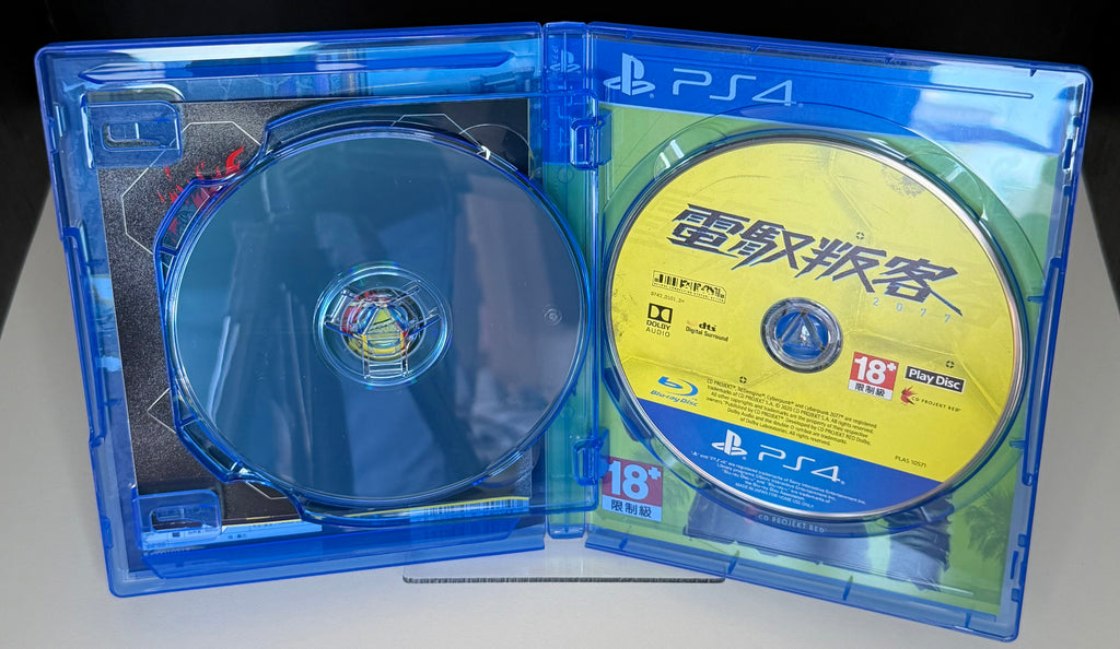 Cyberpunk 2077 PS4 Asian edition contents laid out showing World Compendium booklet Coyote Codo postcard and Night City Watson district fold-out game map