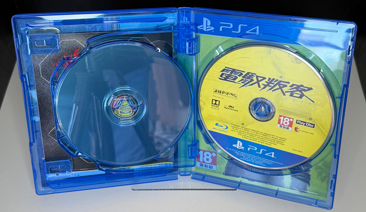 Cyberpunk 2077 PS4 Asian edition contents laid out showing World Compendium booklet Coyote Codo postcard and Night City Watson district fold-out game map
