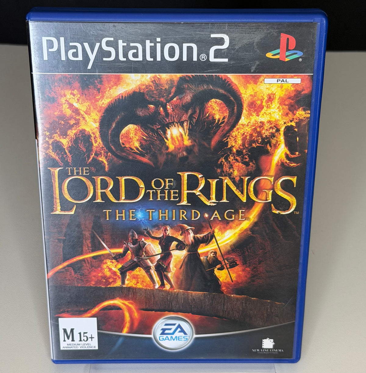Lord of the Rings The Third Age PS2 front cover showing Balrog fire demon with Fellowship heroes and M15+ rating on ANZ blue PS2 case