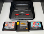 Sega Mega Drive II PAL console bundle showing slim black 16-BIT console with Cartridge Input slot and red Power Reset buttons alongside three loose Mega Drive cartridges Columns Blockout and Sonic the Hedgehog 2